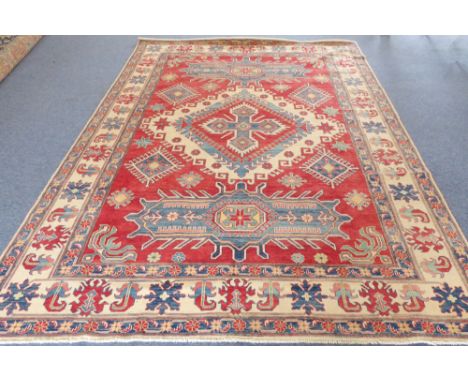 A large modern Pakistan Ziegler carpet in the Kazakh style (modern): red ground with stylised central lozenge within two thin
