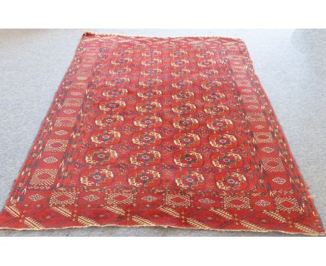 An early 20th century&nbsp;Tekke&nbsp;Turkeman carpet: four rows of ten guls on a red field with a wide main border with alte
