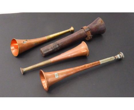 Three hunting horns:an early 20th century brass and copper example in its leather case;a slightly curved example; a silver-pl