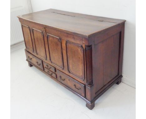 A mid-18th century oak mule chest: the top with three brass hinges and opening to reveal a later oak-faced ply lining; four-p