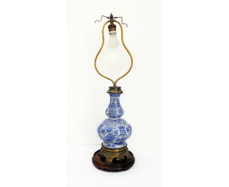 A brass-mounted blue-and-white table lamp on circular Chinese stand: double-gourd form with brass collar of ruyi heads above 