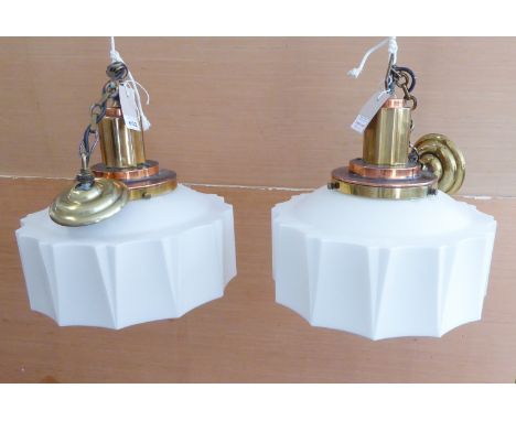 A pair of brass and copper mounted Art Deco style ceiling hanging lamps: brass link chain to an angular brass and copper flut
