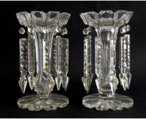 A pair of Victorian clear glass lustres: the printie-cut crown tops on panel-cut stems and petal-cut bases, suspending notch-