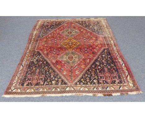A Persian Shiraz carpet (modern, late 20th century): single large red lozenge with dark blue spandrels, possibly stylised sco