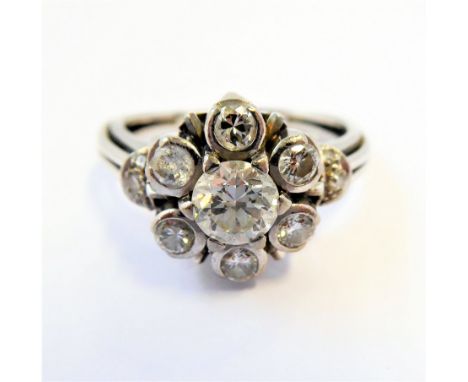A diamond cluster ring, the central brilliant-cut diamond (estimated to spread 0.6ct)&nbsp;claw-set within a surround of six 