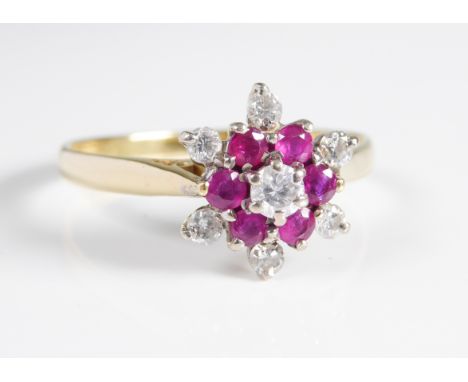 An 18ct yellow gold, ruby and diamond floral cluster ring: the cluster with six round cut rubies and seven brilliant cut diam