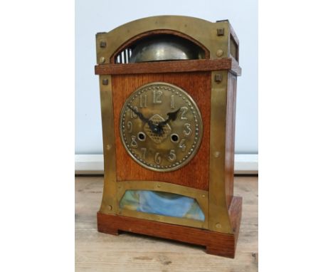 A German Secessionist oak mantle clock, brass mounts and dial, glass panel, double spring driven movement striking on single 