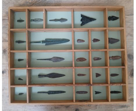 A collection of flint and metal arrow heads, the case measuring approximately 45cm x 37cm.