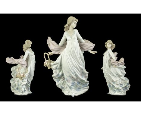 Lladro 'Spring Splendour' Figurine No. 5898, depicts a lady with the wind blowing her shawl, carrying a basket of flowers.  M