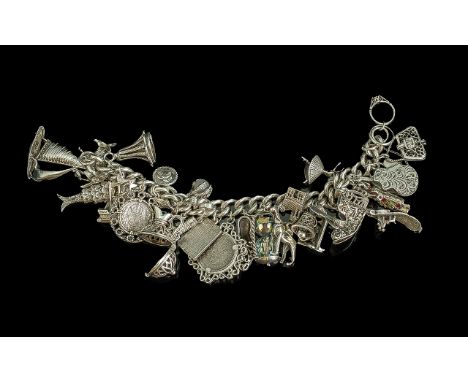 A Superior Quality Sterling Silver Charm Bracelet - Loaded with Approx 30 Silver Charms. Bracelet and Charms Marked Silver. W