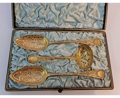 A boxed pair of Georgian engraved silver gilt serving spoons and a ladle, spoons hallmarked London 1803 with makers marks for