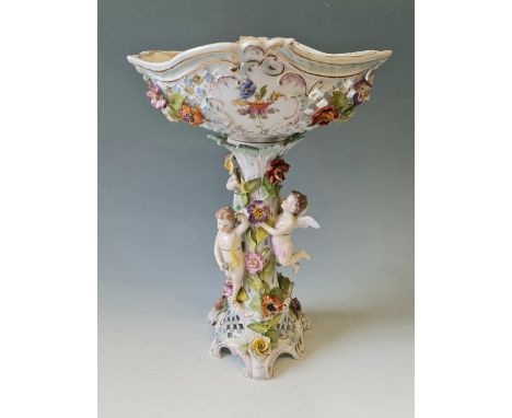 A Dresden porcelain centrepiece with pierced basket top three cherubs to column and flowers throughout, height 46 cm.