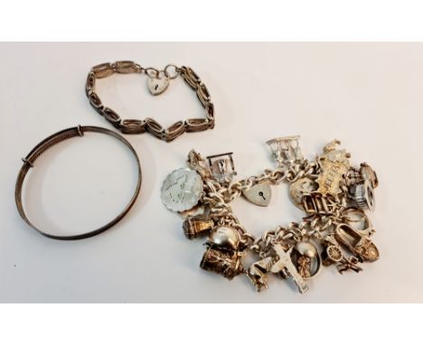 A hallmarked silver charm bracelet with approx. 23 charms, some stamped silver, along with a gate style bracelet, stamped on 