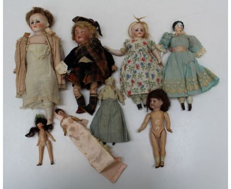 A collection of eight, mostly early 20th century bisque and porcelain dolls, including an Armand Marseille Highland doll, hea