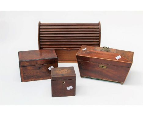 An early 19th century mahogany tea caddy, a desk top tambour front stationary companion, two further tea caddy's and an ebony