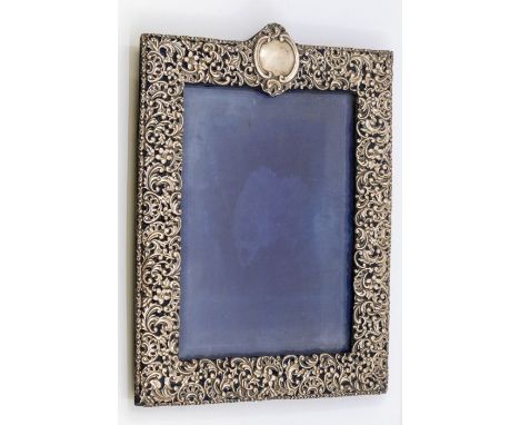 A large Victorian silver pierced frame, with central vacant cartouche, profusely chased and pierced with flowers and foliage,