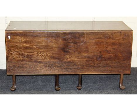 A George III oak dining table, rectangular top and twin drop leaves with double gate supports, on turned tapering legs and pa
