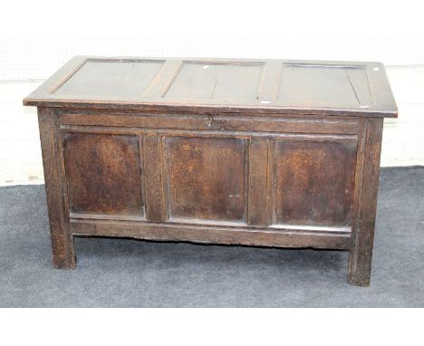 A late 17th century oak coffer, the three panel top and front on fluted stile supports enclosing a vacant interior, 120cm wid