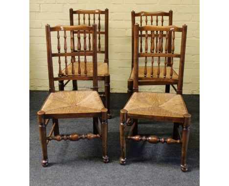 A set of four 20th century beech and elm double comb back rush seated dining chairs
