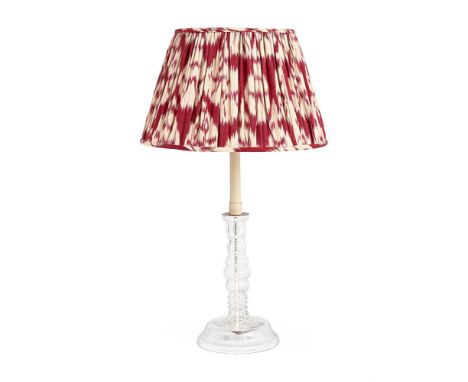A CLEAR GLASS CANDLESTICK LAMP BASE SECOND HALF 20TH CENTURY  With Robert Kime Ikat red carnation style shade  72cm high over