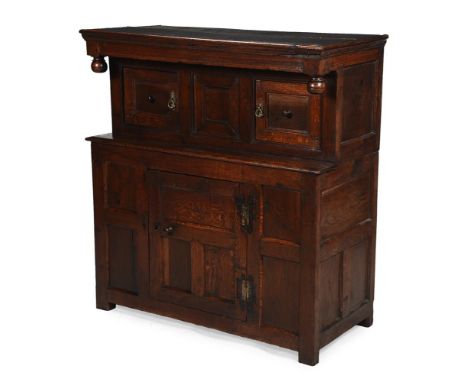 AN OAK COURT CUPBOARD 17TH CENTURY   With channelled frieze and compressed spherical pendants, the panelled recessed front wi