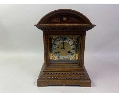 OAK MANTEL CLOCK, with dome top and brass face depciting Roman numerals38cm high