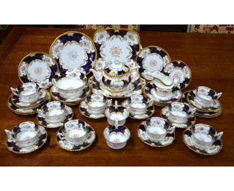 A Coalport china 'batwing' tea service, printed and enamelled with floral sprays on a Royal blue and gilt ground, comprising 