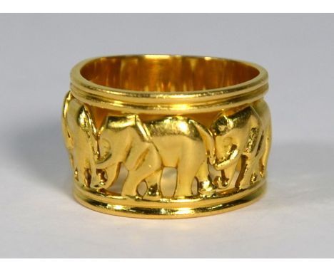 A yellow metal wide open work band ring with central pierced frieze of elephants and a flat sectional back, size K, 1 cm wide