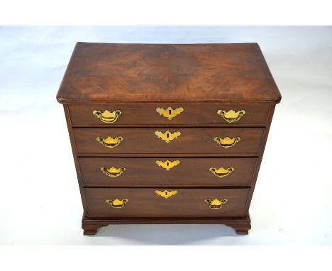 A compact Georgian style cross-banded mahogany chest of four long graduated drawers, with brass fittings, raised on moulded b