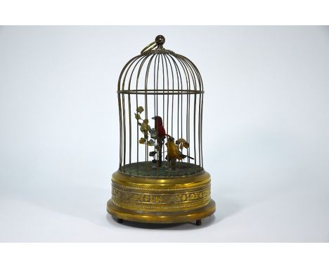 A Swiss singing birds-in-a-cage automaton, with two feathered moving birds on a branch, in brass cage, clockwork movement, wo