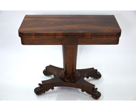 A 19th century rosewood fold-over card table, with circular baize lining raised on a turned support to a quad platform base, 