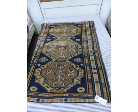 A small Kuba rug early 20th century, the row of three joined octagonal medallions in buff, light brown, blue,