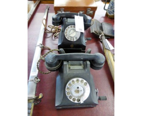 Two vintage wind-up black bakelite phones with applied Guernsey crests. (2)