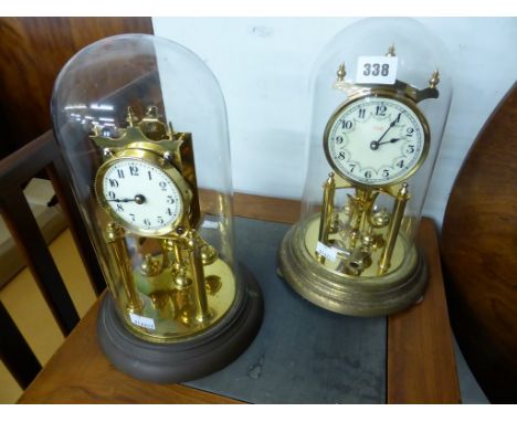 Two brass anniversary clocks with glass domes comprising one early 20th century example by Schatz, with Arabic enamel dial,