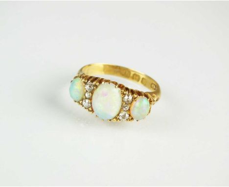 An Edwardian nine stone opal and diamond ring, designed as three graduated oval opal cabochons interspersed with six old cut 