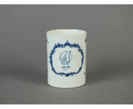 A rare and early Caughley monogrammed mug dated 1776 painted in blue with fruit sprays, an elaborate scroll cartouche enclosi