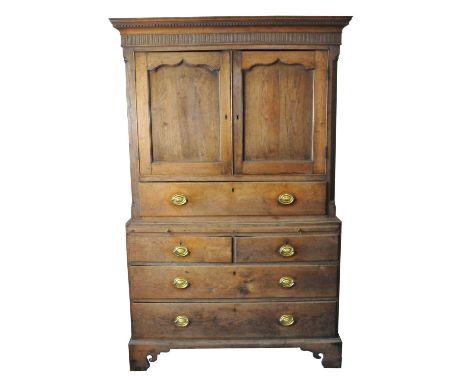 An 18th century oak linen press, the cavetto cornice above two shaped, panelled doors enclosing a shelf, flanked by a reeded 