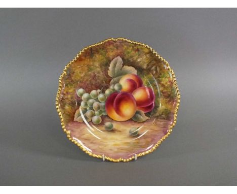 A Royal Worcester cabinet plate of circular form with a scalloped gilded edge, painted with peaches and grapes by J. Skerrett