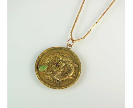 A yellow metal pendant on chain, the circular pendant depicting a four clawed dragon grasping pear shaped jade cabochon with 