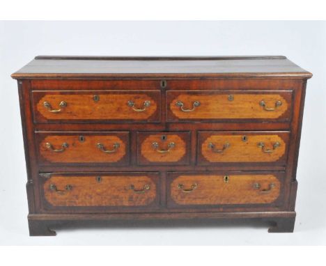 An 18th century oak and mahogany crossbanded Lancashire mule chest, the ovolo lip-moulded drawers with brass swan neck handle