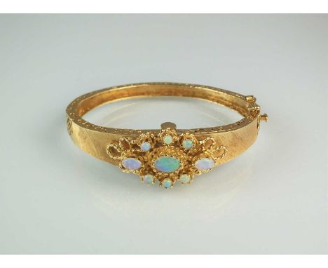 An opal set Catena bangle wristwatch, the textured matt yellow metal bangle set with nine cabochon opals, mounted to open wor