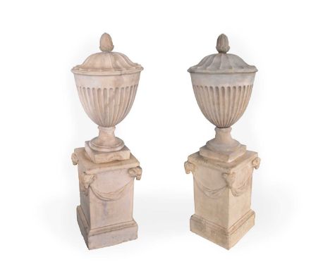 A pair of Coade urns, with bud form finials and fluted sides, bases impressed 'Coade Lambeth 1794', 63cm high, with a pair of