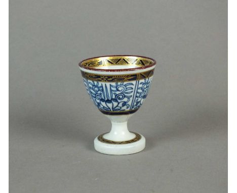 A rare Caughley 'Lily' egg cup circa 1785 the deep bowl supported on a slender stem above pedestal foot, painted with the 'Li