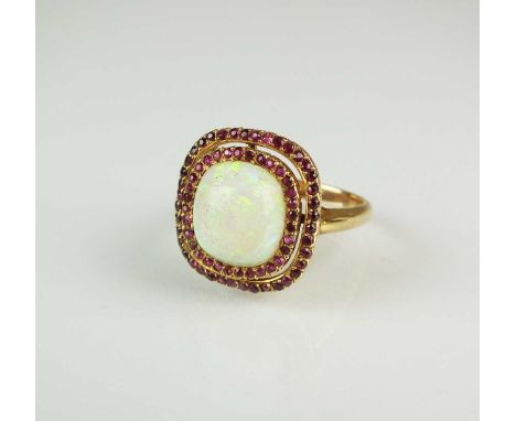 A ruby and opal cluster ring, designed as a central cushion cut cabochon opal within two borders of faceted rubies, all mount