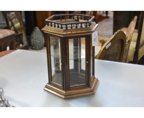 A 19th century glazed walnut table top display cabinet, of hexagonal form, with baluster gallery over glazed panels, two hing