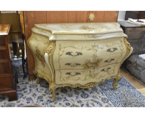 A Venetian style painted and parcel-gilt bombe commode, of serpentine form, fitted with three long drawers, decorated through