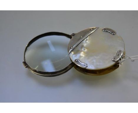 A silver and mother-of-pearl folding magnifying glass, early 19th century, circular, the hinged lens in a reeded silver frame