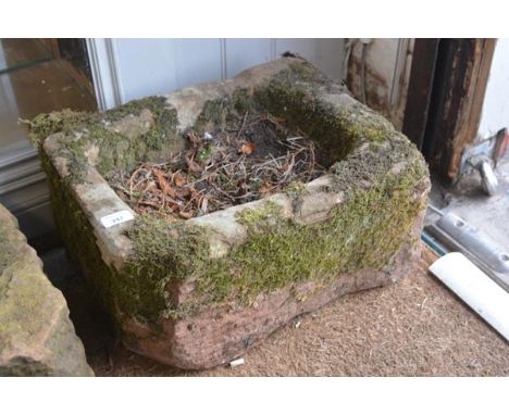 A rectangular weathered stone trough planter. 24cm by 47cm by 36cm