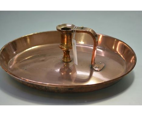 An unusual 19th century copper chamber stick, the very large pan centred by a baluster knop with tapering loop handle. 39.5cm