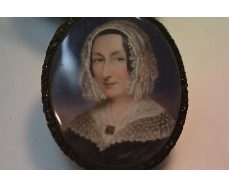 English School, c. 1840, a portrait miniature of a lady in a lace cap, watercolour on ivory, in a gilt metal frame with glaze